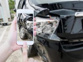 kvinnlig håll mobil smartphone som fotograferar bilolycka foto
