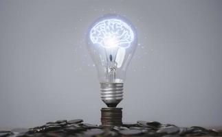 glödande virtuell hjärna inuti glödlampa på myntstapling för kreativt tänkande idé och innovation kan tjäna mer pengar koncept. foto