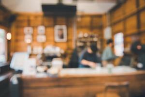 kafébakgrund, abstrakt oskärpa av interiörkafé och restaurang. kaffeinteriör barutrymme för kundernas avkoppling. suddig bokeh glödlampa i café butik foto