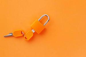 orange färg hänglås och nyckel på bordet foto