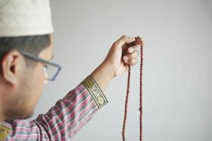 muslimsk man håller handen i berande gester under ramadan, närbild foto