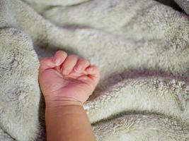 baby hand på grå filt. nyfödda känner sig trygga och varma. selektivt mjukt fokus. foto