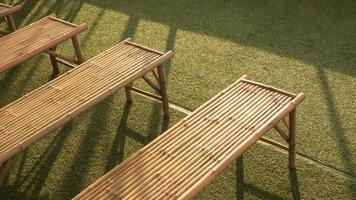 hög vinkel vy av bambu bänkar på grön gräsmatta med solljus och skugga på ytan foto
