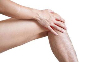 man med både handflatan runt knäskålen för att visa smärta och skada på knäområdet., vit bakgrund foto