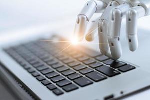 robot finger pekar och arbetar till laptop tangentbord knapp, ai, artificiell intelligens, robot hand på digital grå bakgrund. futuristiskt teknikkoncept. foto