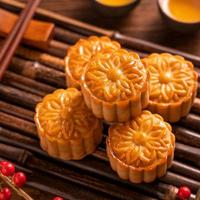 kinesiska traditionella bakverk moon cake mooncake med tekoppar på bambu servering varningsbricka på trä bakgrund för midhöstfestivalen, närbild. foto