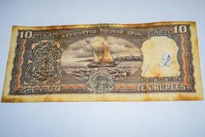 sällsynt gammal indisk tio rupier sedel på vit bakgrund, Indiens regering tio rupier gammal sedel indisk valuta, gammal indisk sedel på bordet foto