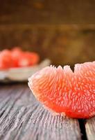 färsk mogen grapefrukt med skivor på ett träbord foto