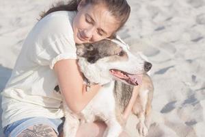 kvinna leker med hund på stranden foto