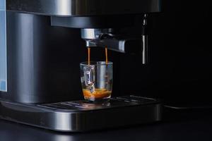 espressokaffe från en kaffemaskin i droppglas foto