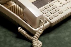 vintage telefon med lur och telefonsvarare på grön sammet, luren ligger bredvid. foto