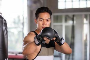 porträtt av ung man tränar boxning på gym. foto