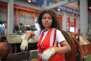 kvinnlig arbetare förman eller arbetare arbete på fabriksplatsen kontrollera maskin eller produkter på plats. ingenjör eller tekniker som kontrollerar material eller maskin på anläggningen. industri och fabrik. foto