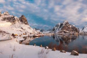 landskap av norsk by i snödalen på kustlinjen vid Lofotenöarna foto