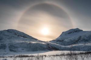 snö bergskedja med sol halo på vintern foto