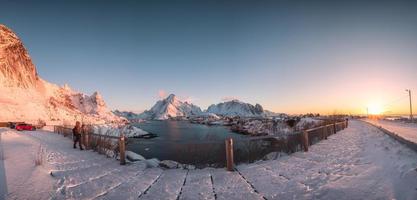 solnedgång på fiskeby med snöiga berg vid reine foto