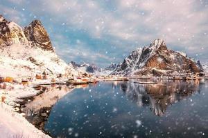 skandinavisk by i snöig dal vid kusten med snöfall på morgonen foto