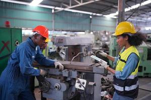 underhållsingenjörer arbetar framför den automatiska reparationen av cnc-maskiner på en checklista för underhåll vid produktionslinjen. foto
