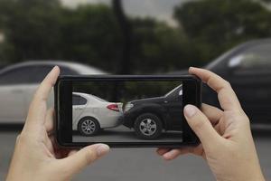 hand som håller smart telefon ta ett foto på platsen för en bilolycka, bilolycka för försäkring