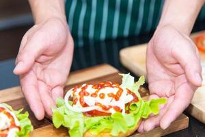 kocken förbereder bröd lök tomat grönsaker och gör hamburgare i köket. foto