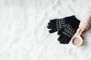 ovanifrån av kvinnliga händer som håller glas fyllt med varm choklad och handskar med kopia utrymme för vinter bakgrund koncept foto