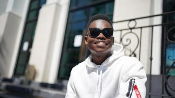 afroamerikansk man har roligt att gå i stadens centrum - glad ung kille som njuter av tiden en solnedgång utomhus - tusenårig generation livsstil och positiva människor attitydkoncept foto