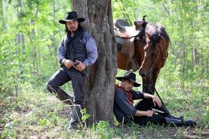 cowboy till häst mot en vacker solnedgång, cowboy och häst vid första ljuset, berg, flod och livsstil med naturligt ljus bakgrund foto