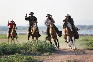 cowboy till häst mot en vacker solnedgång, cowboy och häst vid första ljuset, berg, flod och livsstil med naturligt ljus bakgrund foto