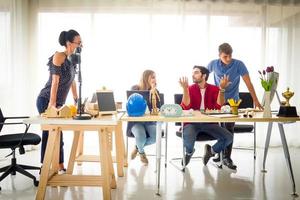 mångfaldig grupp unga affärsmän diskuterar ett arbetsprojekt medan de sitter tillsammans vid ett bord på ett modernt kontor. coworking koncept foto