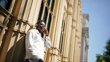 afroamerikansk man har roligt att gå i stadens centrum - glad ung kille som njuter av tiden en solnedgång utomhus - tusenårig generation livsstil och positiva människor attitydkoncept foto