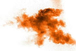 abstrakt orange damm explosion på vit bakgrund. abstrakt orange pulver stänkte på vit bakgrund. foto