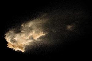 torr flodsandexplosion isolerad på svart bakgrund. abstrakt sand cloud.brown färgad sand stänk mot mörk bakgrund. foto