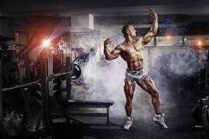 bodybuilder man poserar i gymmet foto