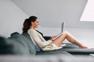 attraktiv brunett surfing internet på laptop foto