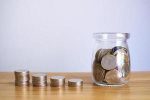 mynt i glasburkar med högar av pengar öka växa spara pengar, finansiella företag investeringsidéer. foto