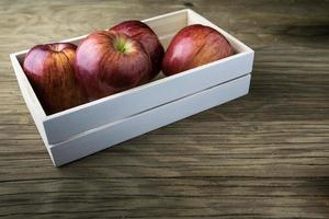 äpplen i lådan. röda äpplen på ett träbord. foto