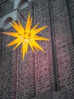 scenisk bild av en stjärnformad lampa som hänger från en byggnad foto