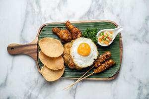 nasi goreng med räkkex och kycklingsatay, indonesisk maträtt, kycklingsatay stekt ris foto