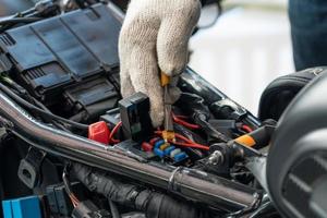 motorcykelmekaniker byter ut ett säkringsbatteri. motorcykel underhåll och service och reparation koncept, selektiv inriktning foto