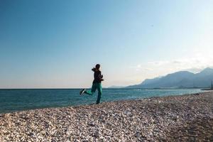 springer på sanden springer en kvinna längs stranden foto