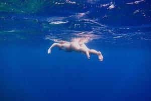 kvinna i bikini flyter i havet foto