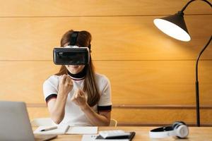 kvinna som bär virtuell verklighetsglasögon står på ett kontor. vr glasögon. 360 grader. virtuell verklighet headset. vr spel. bär virtuell verklighetsglasögon. smartphone med vr. virtuell verklighet video. foto