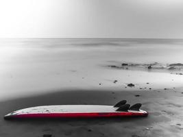 surfbräda övergiven på stranden på vintern foto