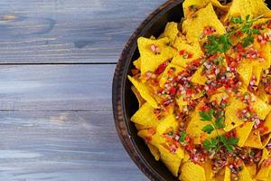 mexikanska nachos med ost. majschips med guacamole, salsa och tomatketchup. foto