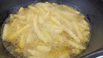 laga pommes frites i stekpannan, krispiga pommes frites, skräpmatskoncept foto