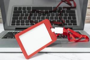 röd namnskylt placerad på en bärbar dator eller anteckningsbok. registrering koncept. foto