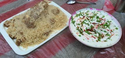 hemlagad nötkött biryani serveras med raita yoghurtdipp, ovanifrån foto