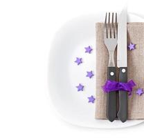 närbild av en kniv och gaffel på en vit platta med servett foto