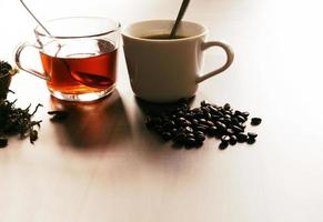 kaffe och te med kaffebönor och teblad på trägolv. foto