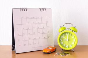 kalender och bil på bordet. dag för köp eller försäljning av en bil eller betalning för hyra eller lån eller reparation foto